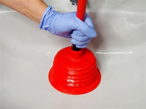 Premium Photo | Unblocking clogged sink with a plunger