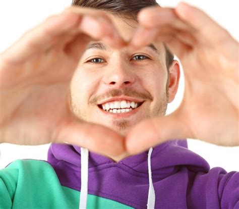 Premium Photo | Smiling attractive young man makes heart using fingers