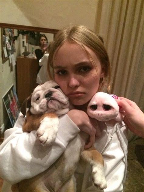 a woman holding two small dogs in her arms