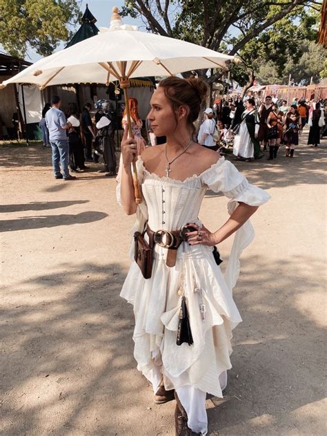 White woman with blonde hair tied into a bun, wearing a white gown with ...