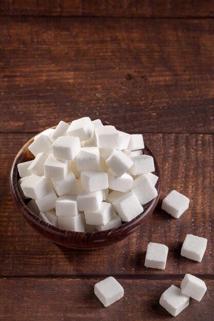 Premium Photo | White sugar cubes in wooden bowl