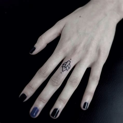 Tiny ornament tattoo on the middle finger - Tattoogrid.net