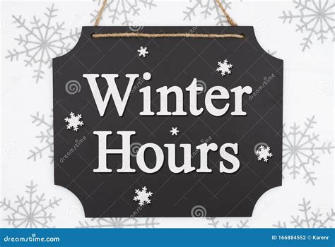 Winter Hours Message on a Retro Hanging Chalkboard with Snowflakes ...