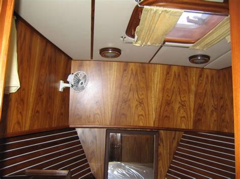 the inside of a boat with wood paneling on the walls and ceiling fan ...