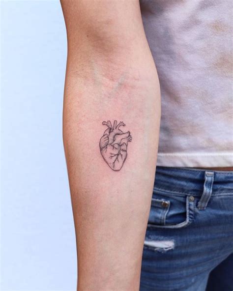 Small anatomical heart tattoo on the inner forearm.