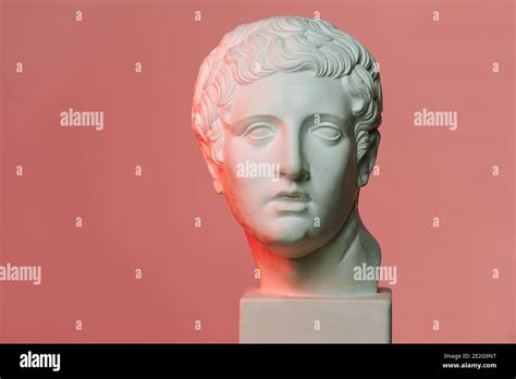 Classic style white marble head of young man over red-lit pink background Stock Photo - Alamy