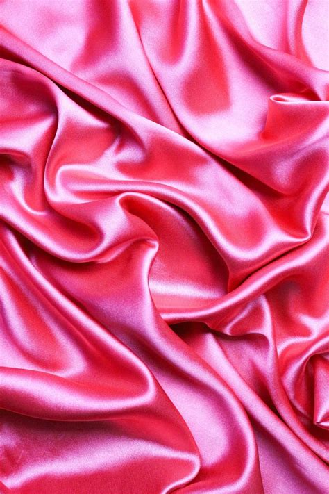 a close up view of a pink satin fabric with very soft folds and smooth lines