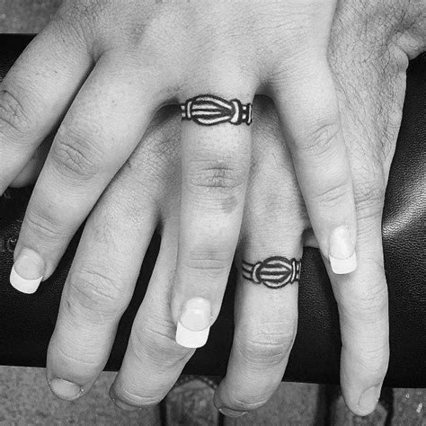 Couples Matching Tattoos on Ring Finger with Knot Design