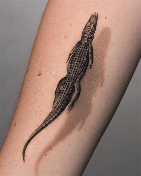 Micro-realistic style alligator tattoo located on the