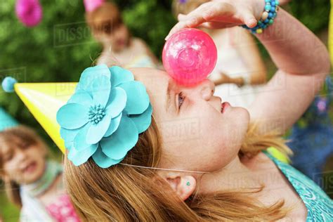 Close up of girl balancing ball on her nose - Stock Photo - Dissolve