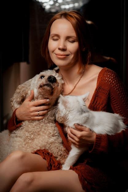Premium Photo | Attractive forty year old woman with a white cat and dog pets care concept