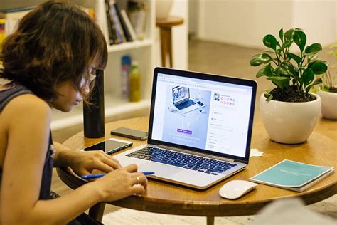 woman, black, tank shirt, facing, laptop computer, brown, wooden, round ...