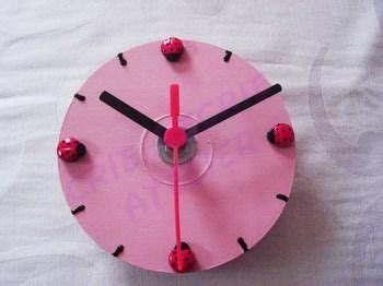 a pink clock sitting on top of a white sheet