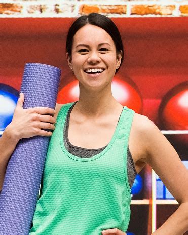 Cute Female Standing At Yoga Studio Holding Mat Stock Photo - Download Image Now - 30-34 Years ...