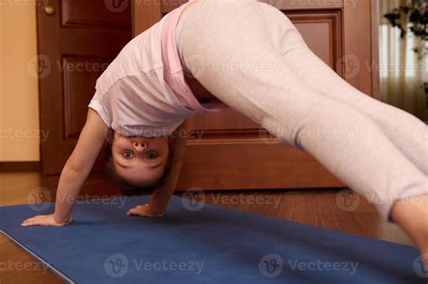 Portrait of 5-6 years old little child girl in downward facing dog pose ...