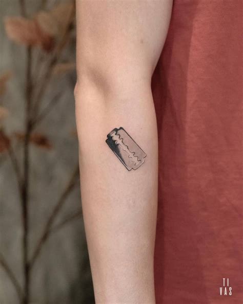 Razor blade tattoo placed on the forearm.