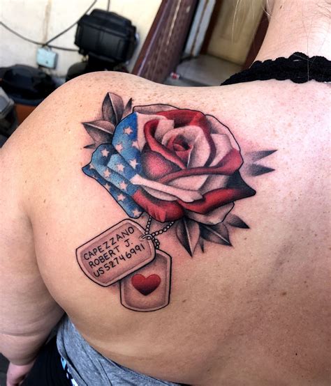 the back of a woman's shoulder with an american flag and a rose tattoo on it