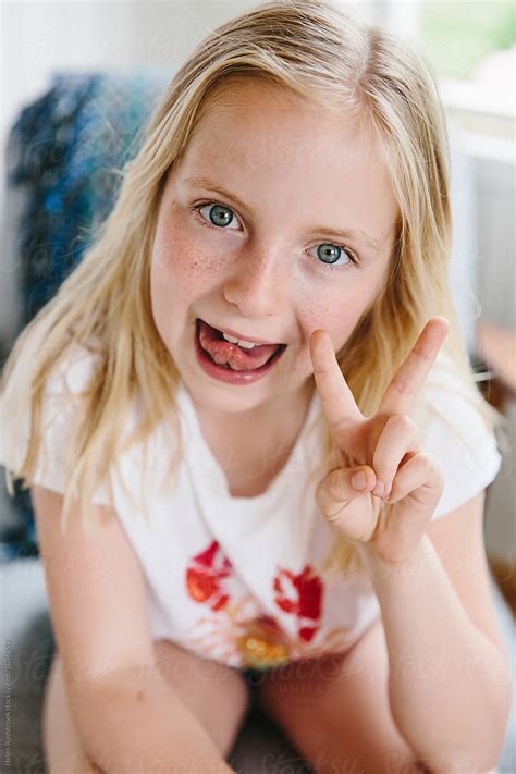 "A Little Girl Sticking Her Tongue Out And Making A Peace Sign." by ...