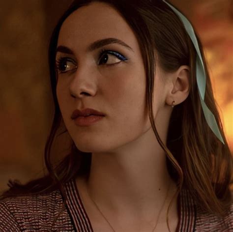 a close up of a person wearing a necklace with a bow in her hair and ...