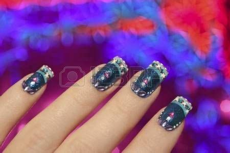 Beautiful winter blue manicure with snowflakes on a brilliant background in the form of ...