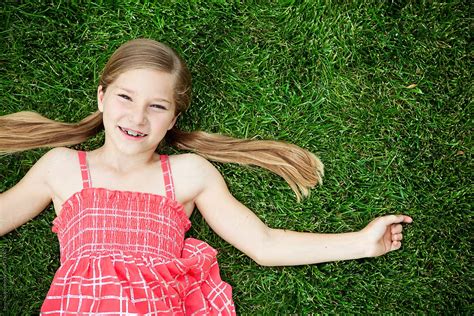 "Grass: Cute Young Girl Lying Back On Grass" by Stocksy Contributor "Sean Locke" - Stocksy