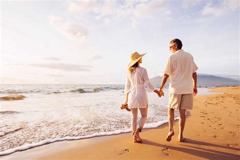 Mature Couple Walking on the Beach at Sunset | MaxLiving