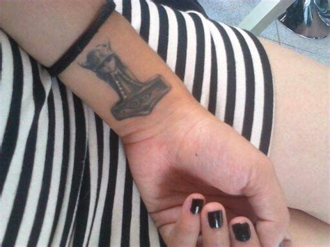 a woman's arm with a small tattoo on it