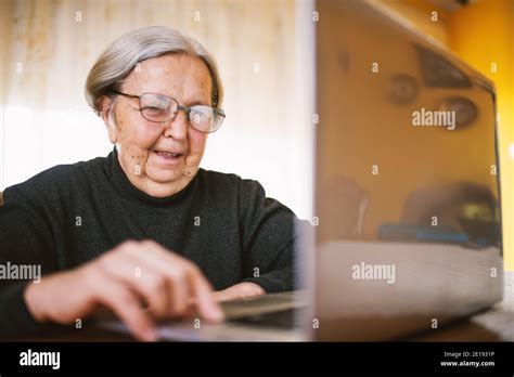 Happy cheerful elderly woman typing on the laptop keyboard Stock Photo - Alamy
