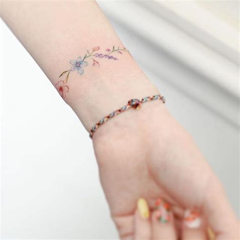 Artist: @anzotattoo | Wrist bracelet tattoo, Small wrist tattoos, Flower wrist tattoos