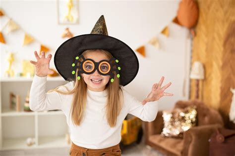 Premium Photo | A girl child in witch costumes is playing pranks on halloween