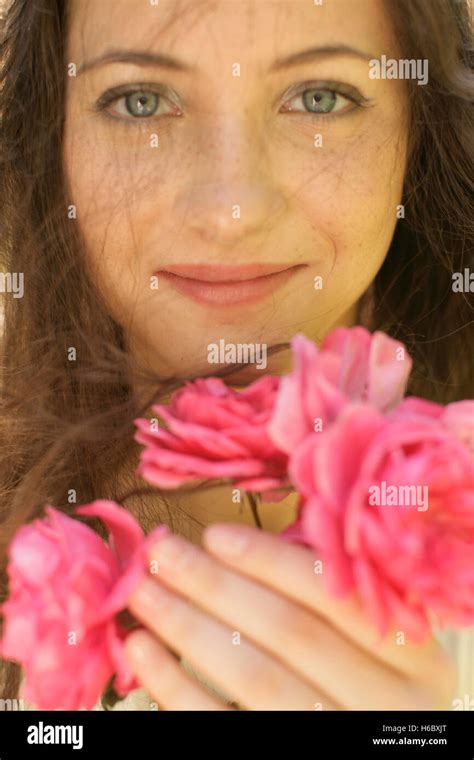 Young woman with pink roses, portrait Stock Photo - Alamy