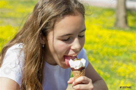 Beautiful teen girl eating ice cream in a waffle cone - stock photo 1337682 | Crushpixel