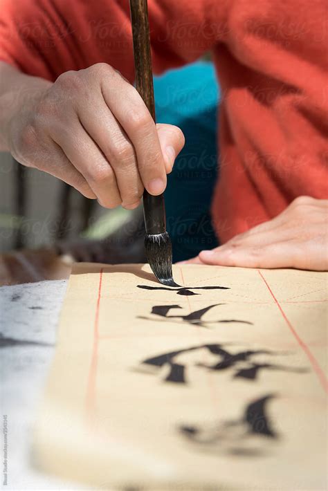 Woman painting chinese symbols - Stock Image - Everypixel