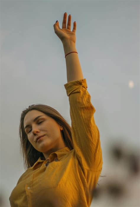 A Woman in Yellow Dress Shirt Raising Her Arm · Free Stock Photo