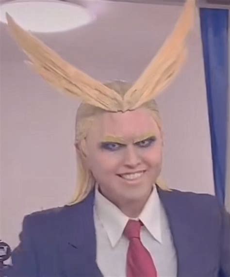 a man with blonde hair and blue eyes wearing a suit, red tie and bunny ears
