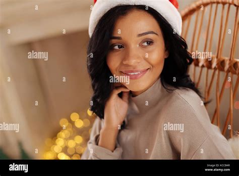 Pleasant woman in Santa hat posing in rocking chair Stock Photo - Alamy