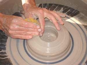 a person making something out of clay on a wheel