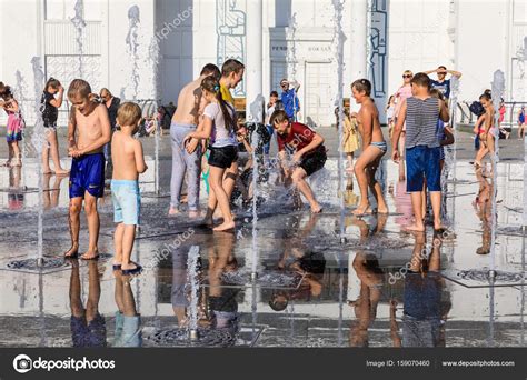 Happy children playing in a water fountain in a hot day – Stock Editorial Photo © palinchak ...