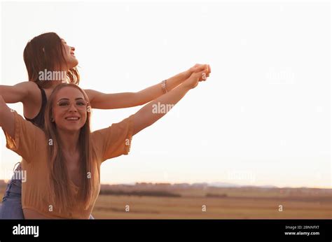 two women holding hands at sunset in the field Stock Photo - Alamy