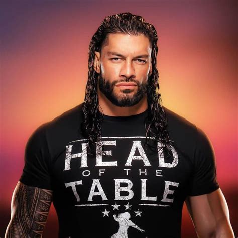 a man with long hair wearing a t - shirt that says head of the table