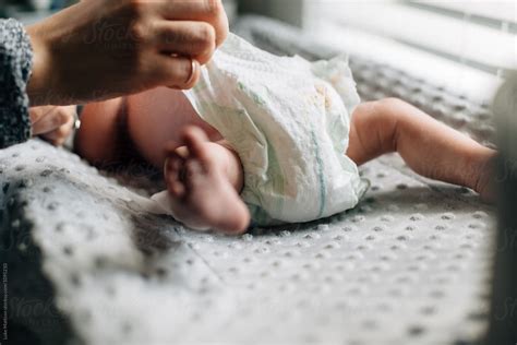 "Mother Changing Diaper Of Newborn Baby Girl On Changing Table" by ...