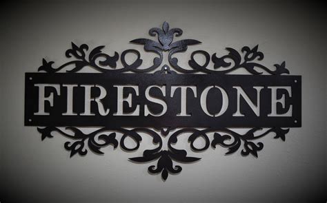 there is a sign that says firestone on the side of a wall in front of a white wall