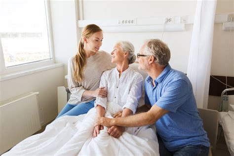 Happy Family Visiting Senior Woman At Hospital Stock Image - Image of ...