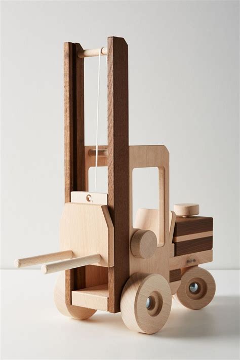 a wooden toy truck with wheels on a white surface