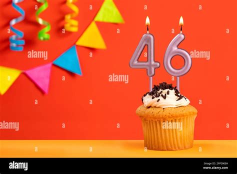 Birthday cake with number 46 candle - Sparkling orange background with ...