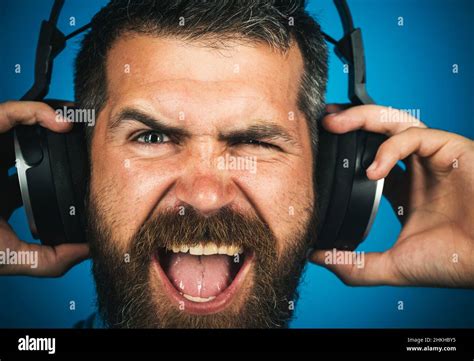 Happy Bearded man with headphones listening music. Perfect song. Smiling man with earphones ...