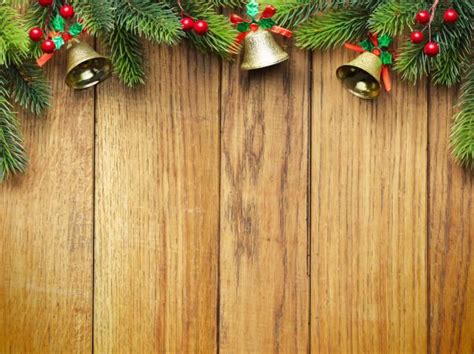 christmas decorations with bells and pine branches on a wooden background, viewed from the top