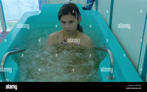 Attractive young girl bathing in a bath in a health spa. The young girls enjoy the outdoor ...