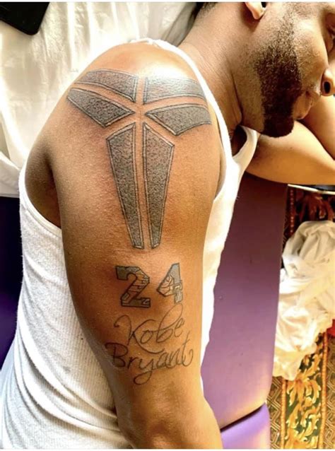 a man with a cross on his arm and some writing on the back of his arm