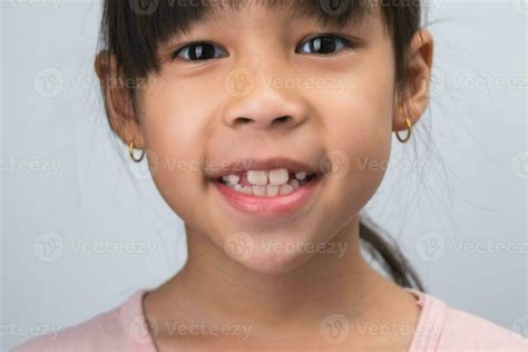 Close-up of cute young girl smiling wide, showing empty space with ...